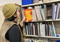 Photographie de la bibliothécaire de liaison qui consulte des livres de la bibliothèque.